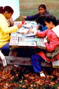 Children sitting at picnic table drawing